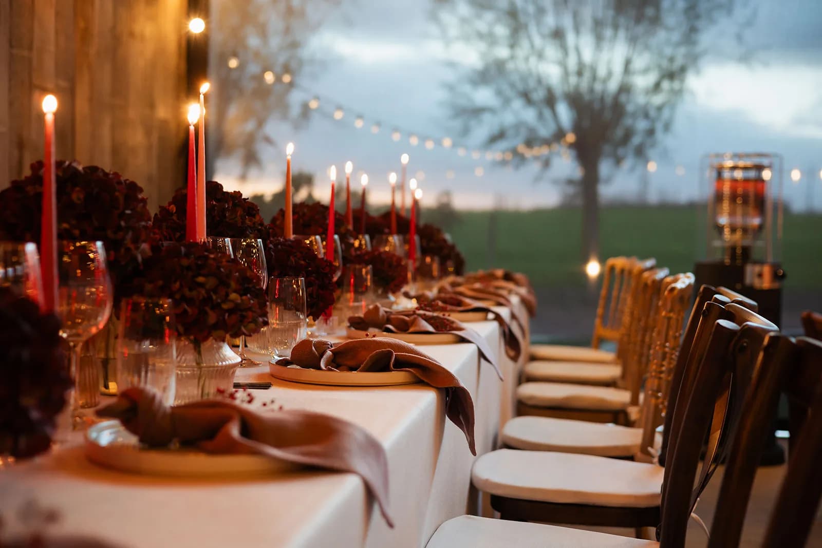 Lange tafel in de schemering met lichtjes